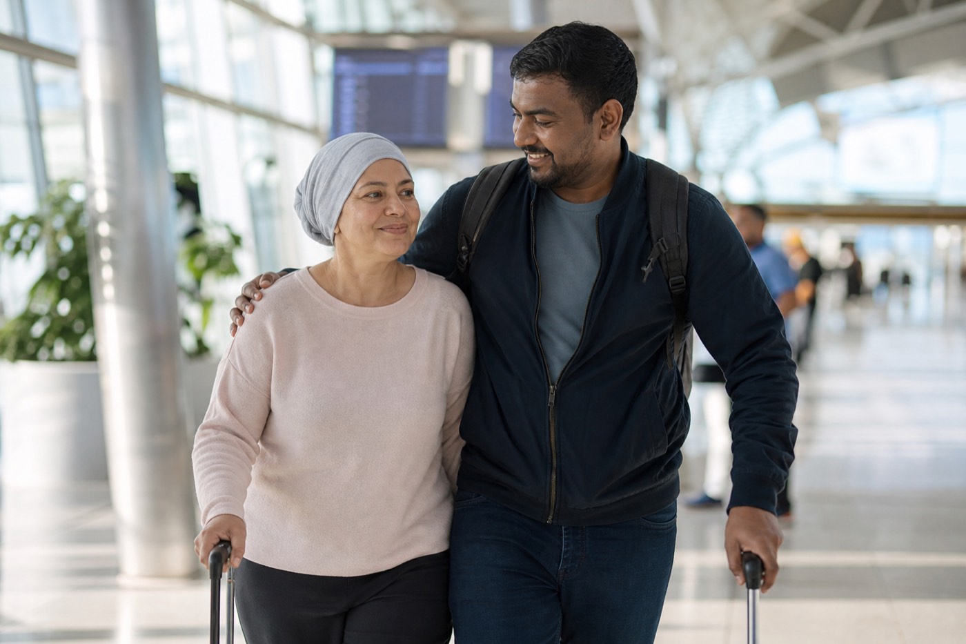 A traveller and companion walking through an airport arrivals hall.
